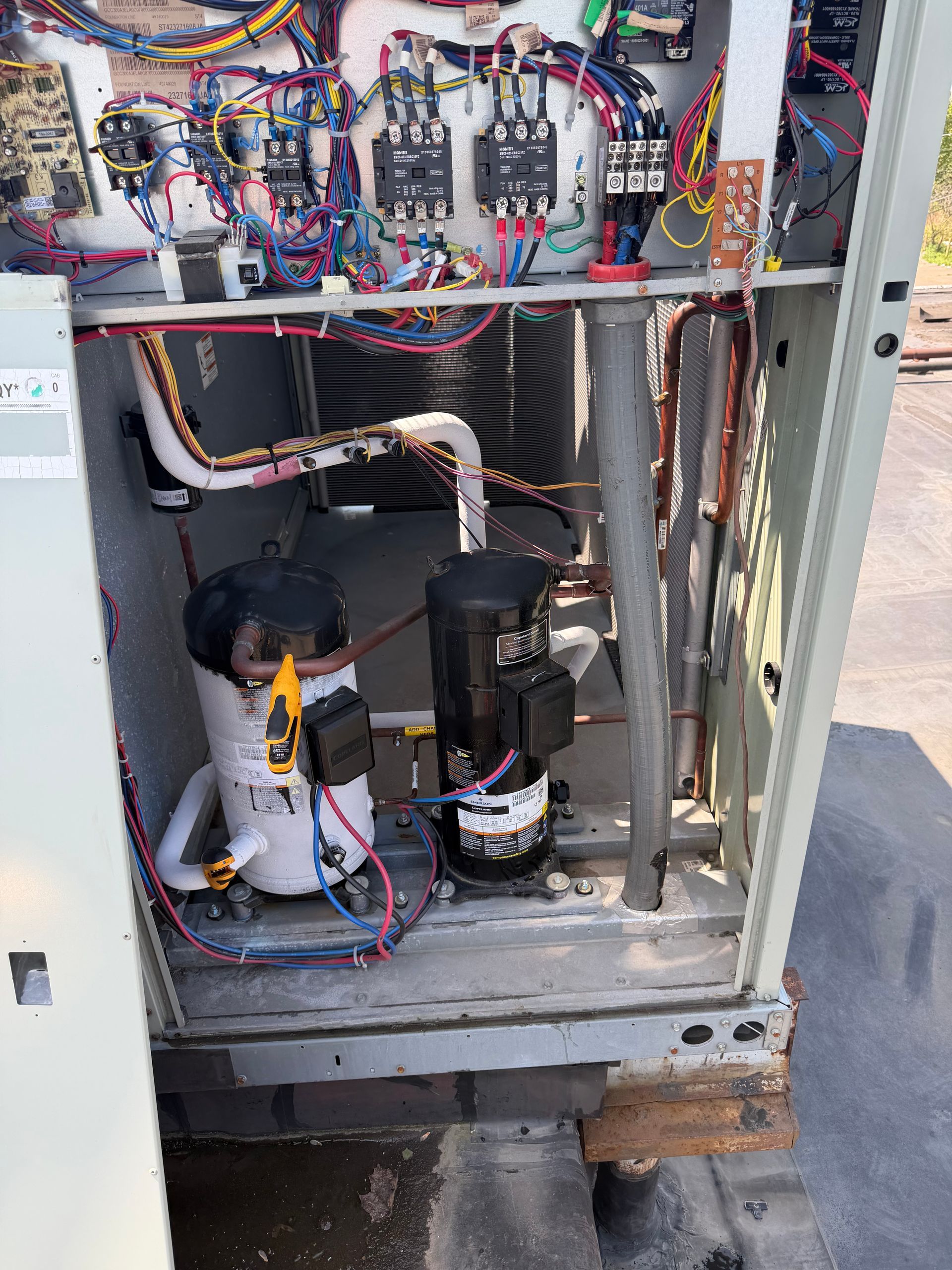 Open electrical cabinet with wiring, relays, and two pump motors inside a metal enclosure.