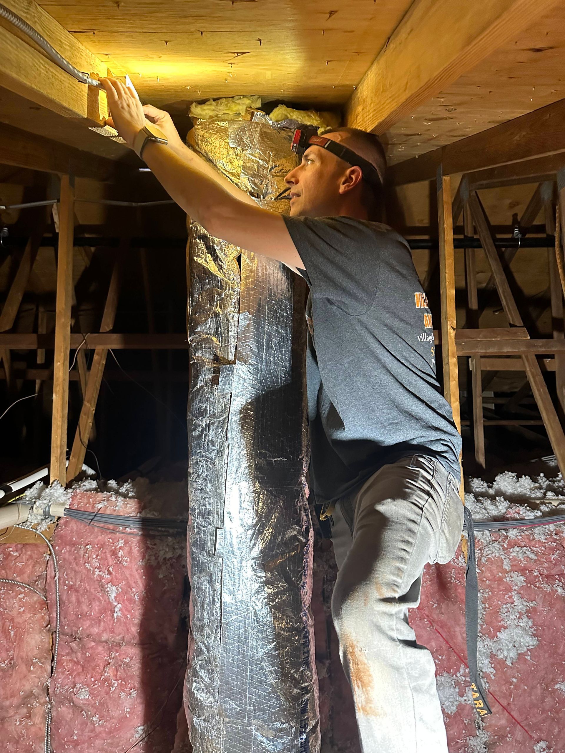 Worker applying spray foam insulation to a crawl space ceiling
