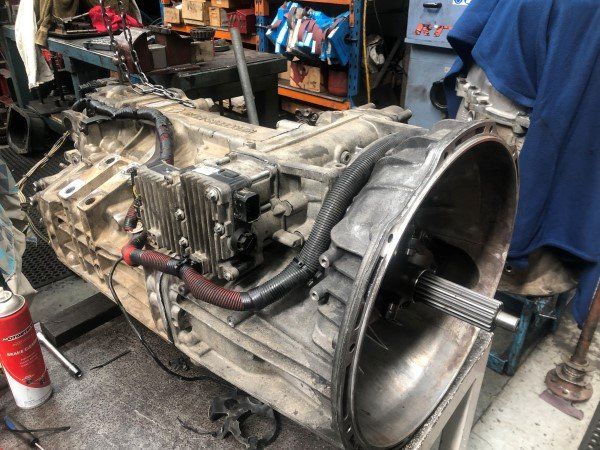 A large gearbox is sitting on a table in a garage.