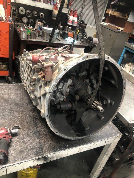 A large gearbox is sitting on a table in a garage.