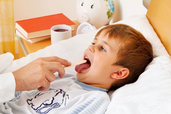 child getting an exam checking throat