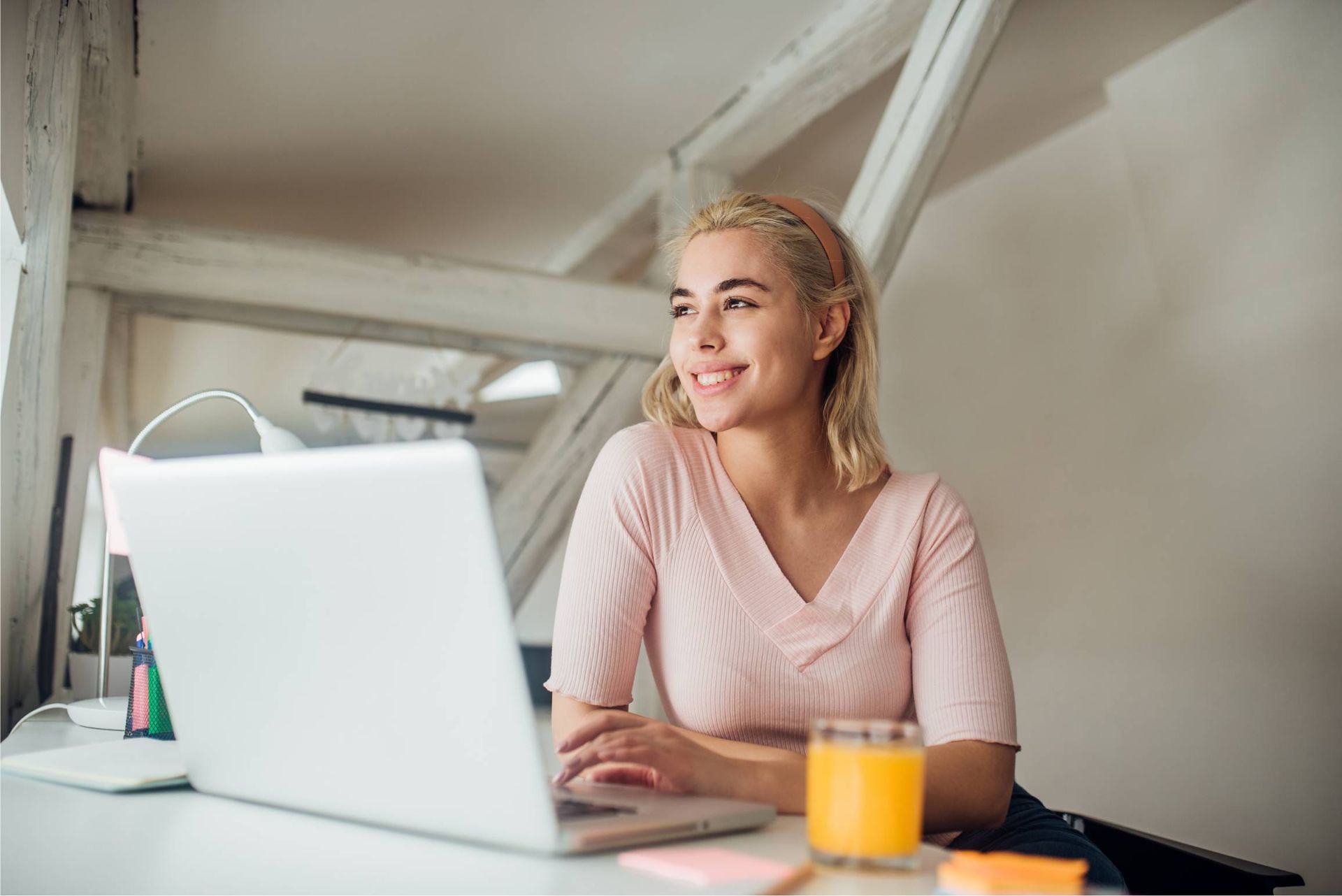 A lady on the laptop smiling leaving a testimony