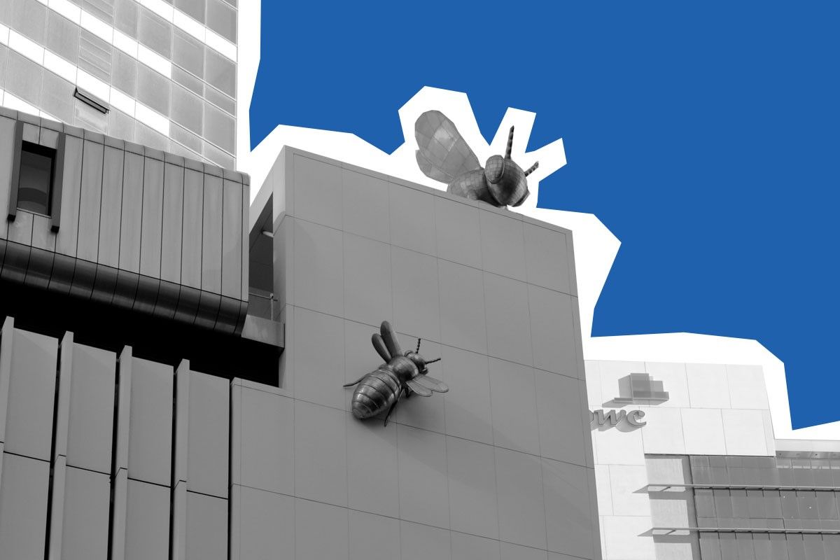 Black and white cityscape with two large bee sculptures on a building wall against a blue background.