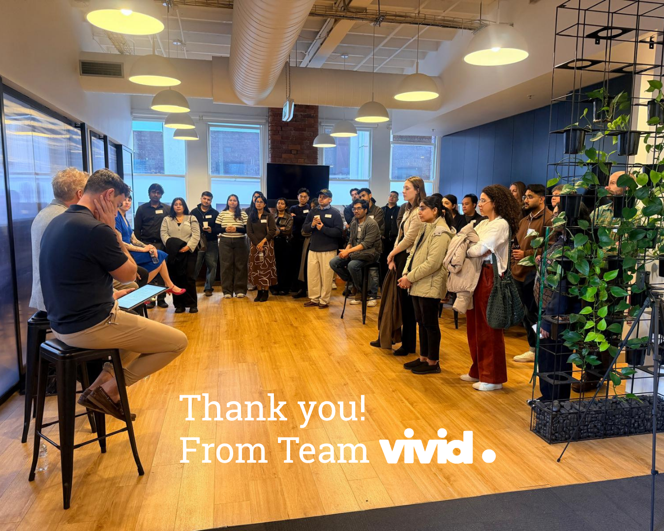 Team Vivid staff gathered in a bright office for a thank-you event, with “Thank you!” text overlay.