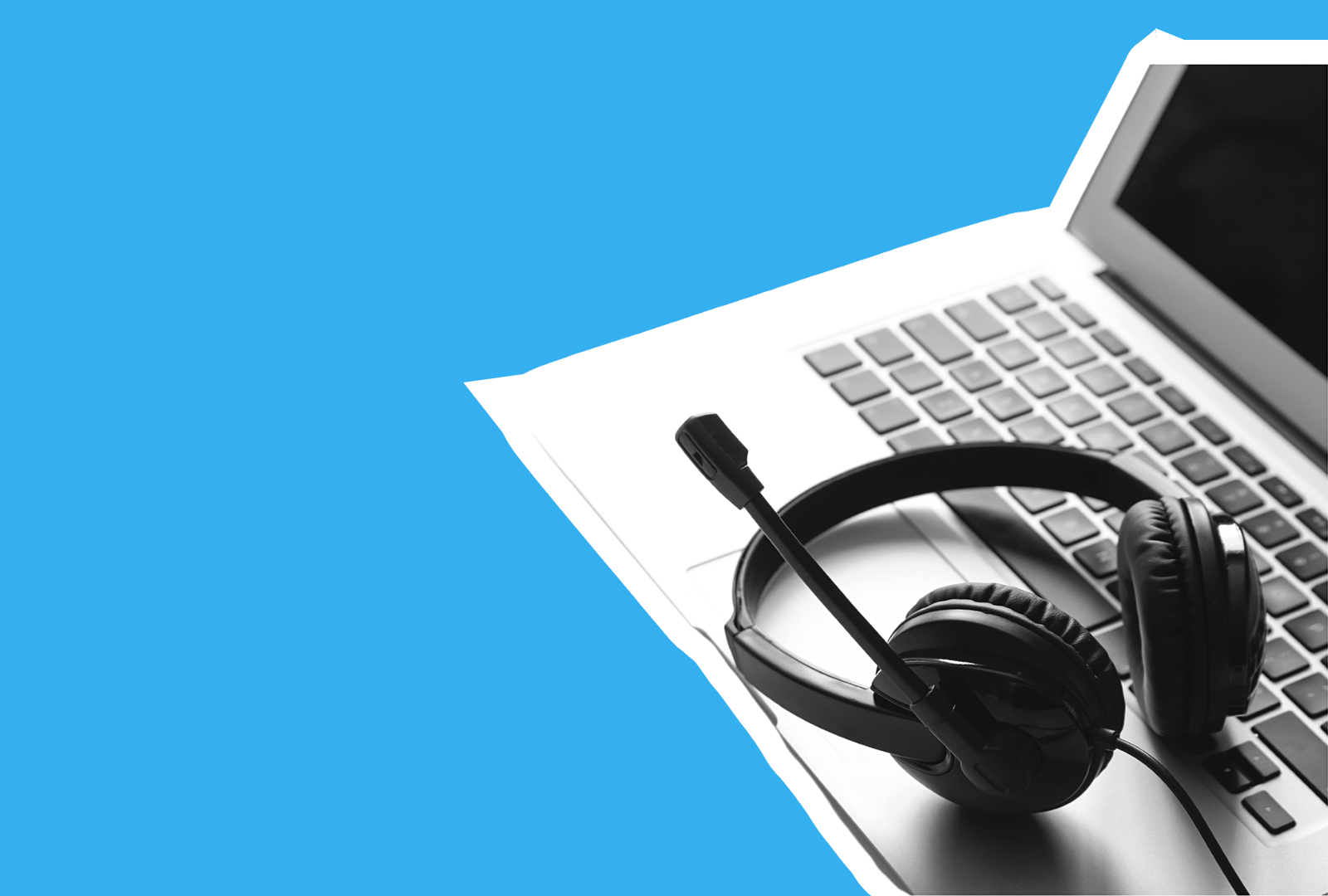 Headphones with microphone resting on a laptop keyboard; blue background.