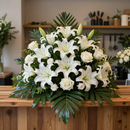 Lirios blancos y rosas dispuestos en un exuberante ramo sobre una mesa de madera en el interior.