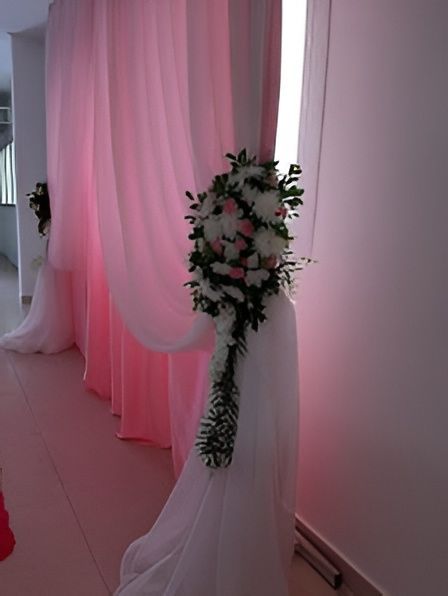 Rosas color melocotón y lavanda con hortensias azules en un jarrón sobre una mesa iluminada con velas.
