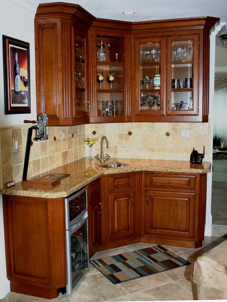 Corner kitchen with wooden cabinets, beige tile backsplash, sink, and built-in appliances