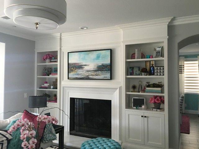 Bright living room with white fireplace, built-in shelves, and a floral couch