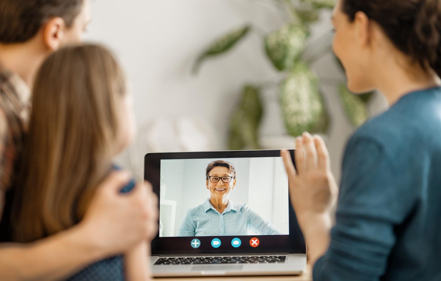 A family is having a video call on a laptop.