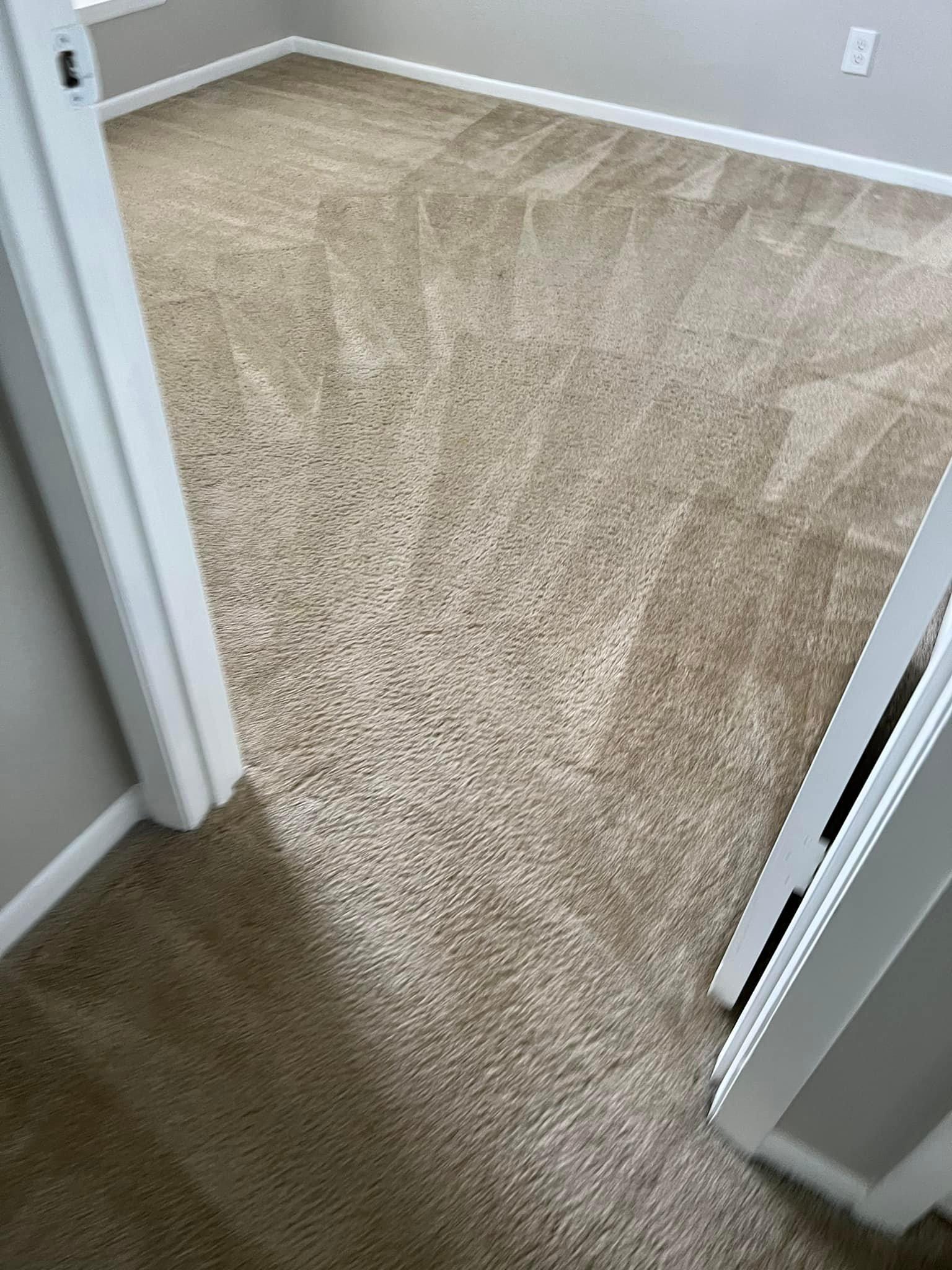 Beige carpeted room viewed from doorway with white trim.