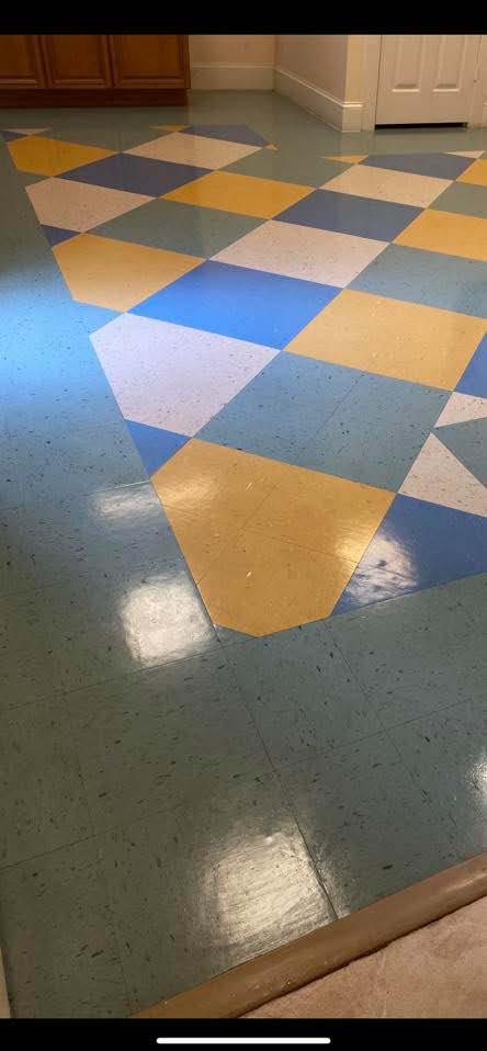 A colorful floor with a diamond pattern of blue, yellow, and white tiles in a room.