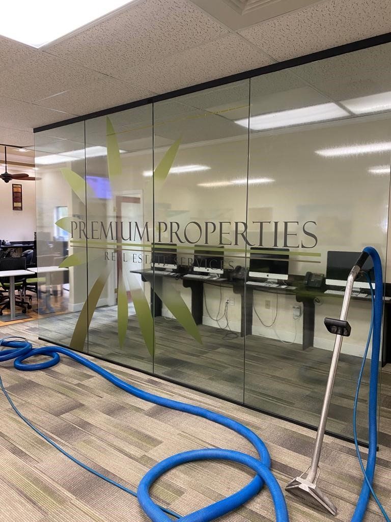 Carpet cleaning equipment in front of a glass wall with 