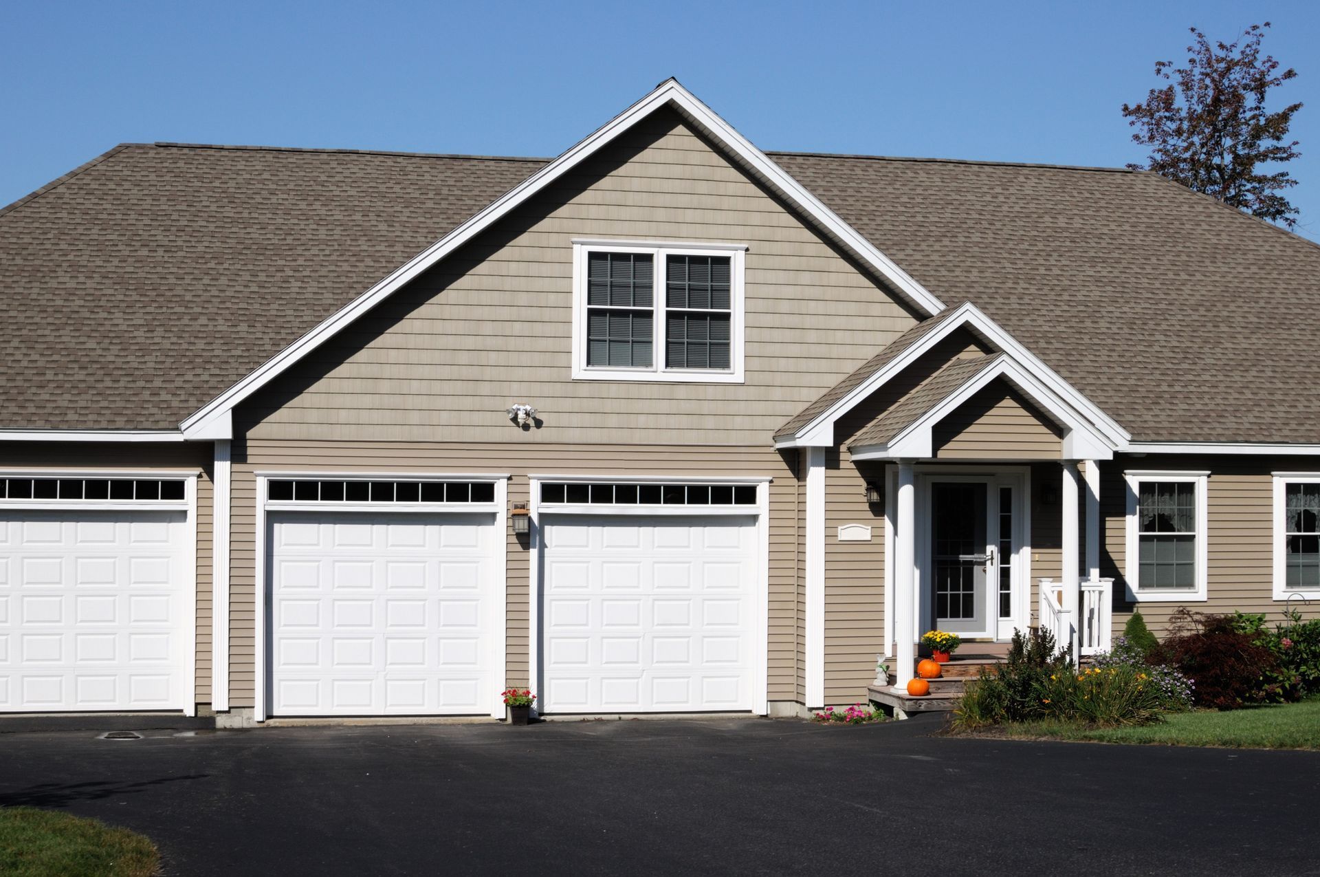 The Front of A House with Three Garage Doors — Paving Contractors In Butler, PA the front of a house with three garage doors