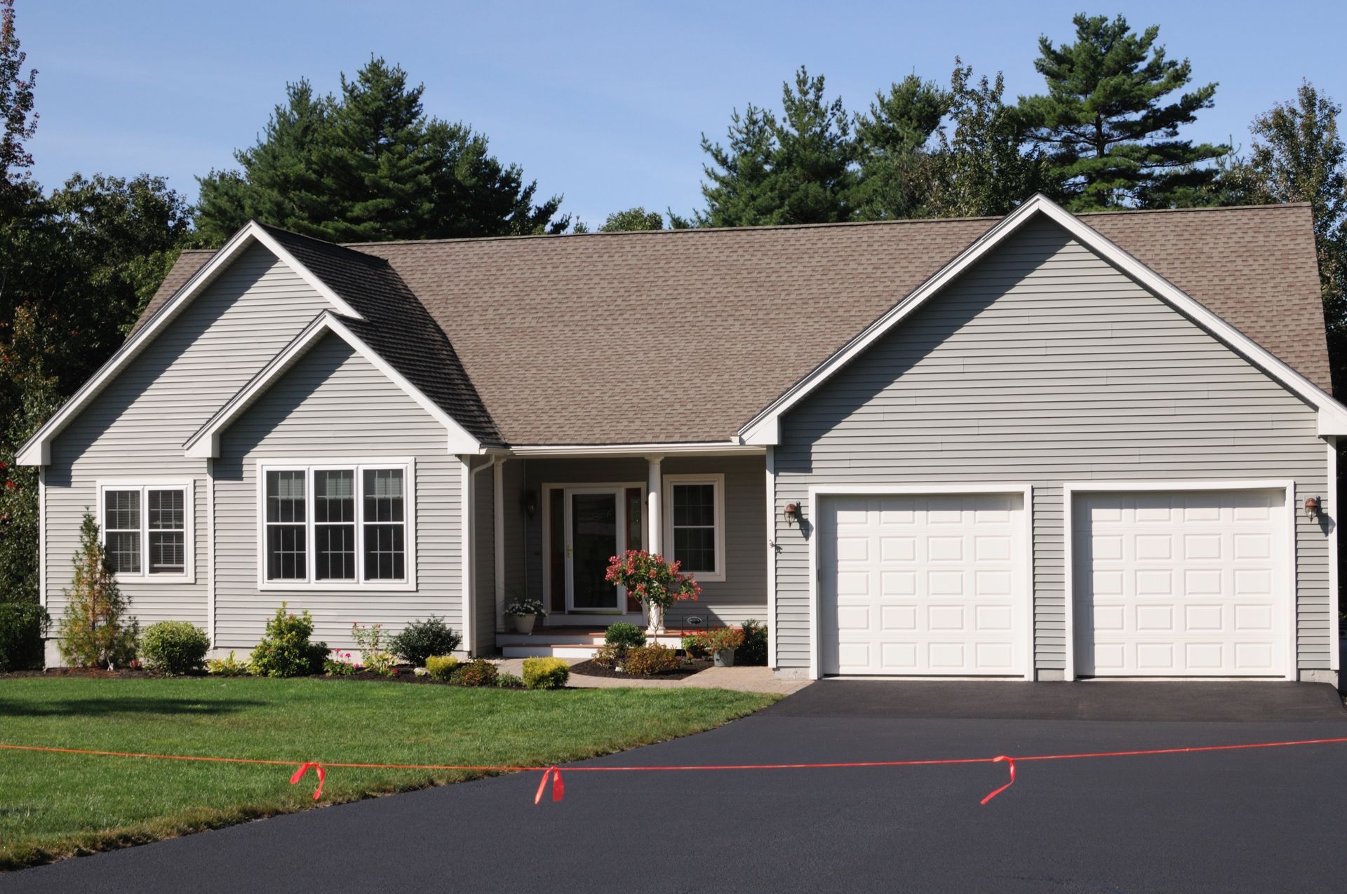 A Large House with Two Garage Doors and A Driveway — Paving Contractors In Butler, PA A Large House with Two Garage Doors and A Driveway — Paving Contractors In Butler, PA