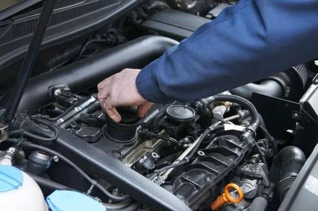 A Man Is Working On The Engine Of A Car — Burleigh Automatics In Burleigh Heads, QLD