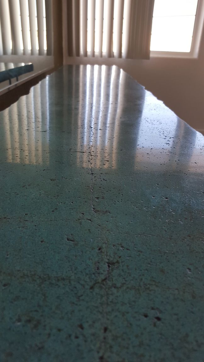 A table in a room with a window and blinds.