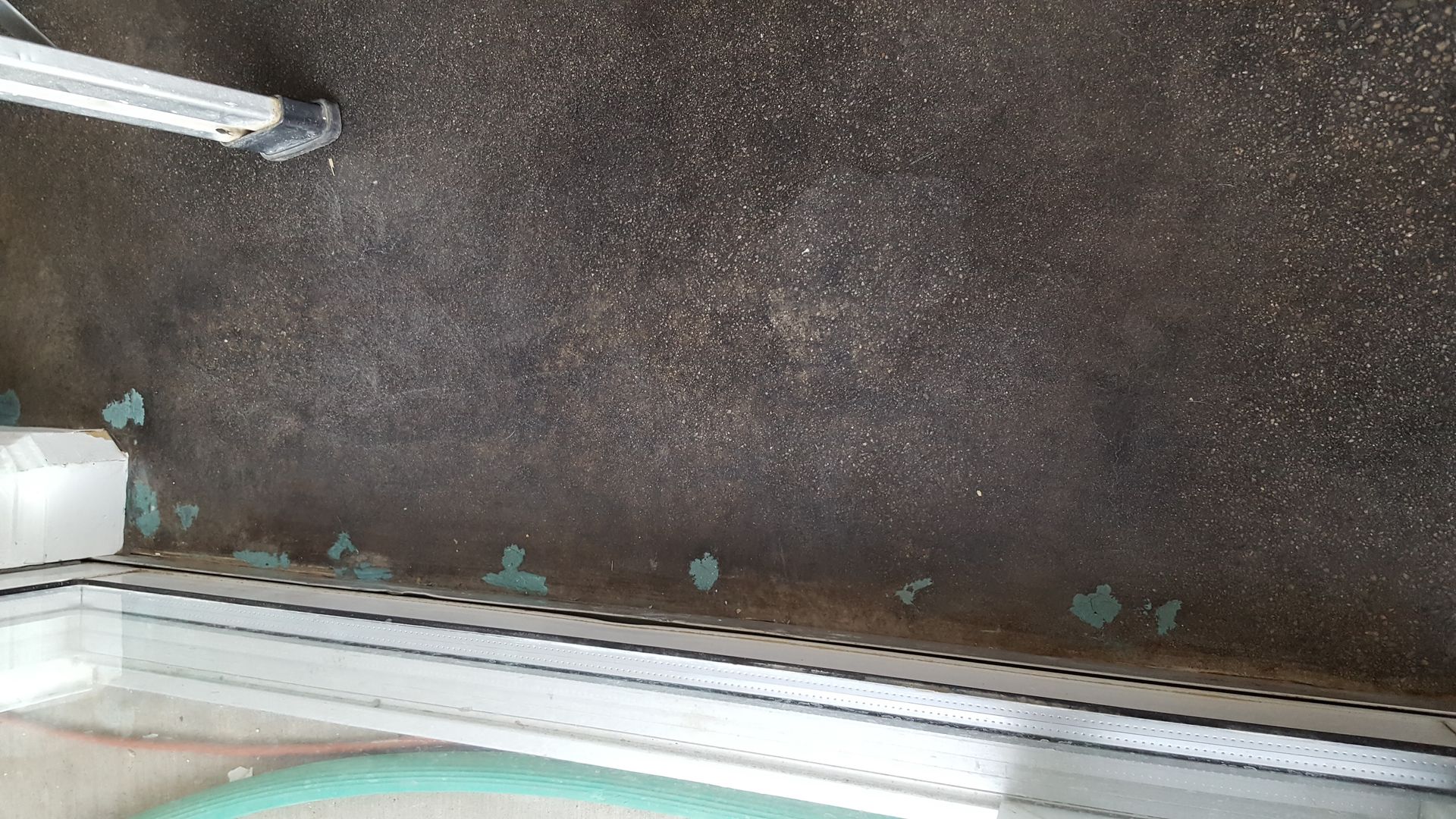 A person is standing on a concrete floor next to a window.