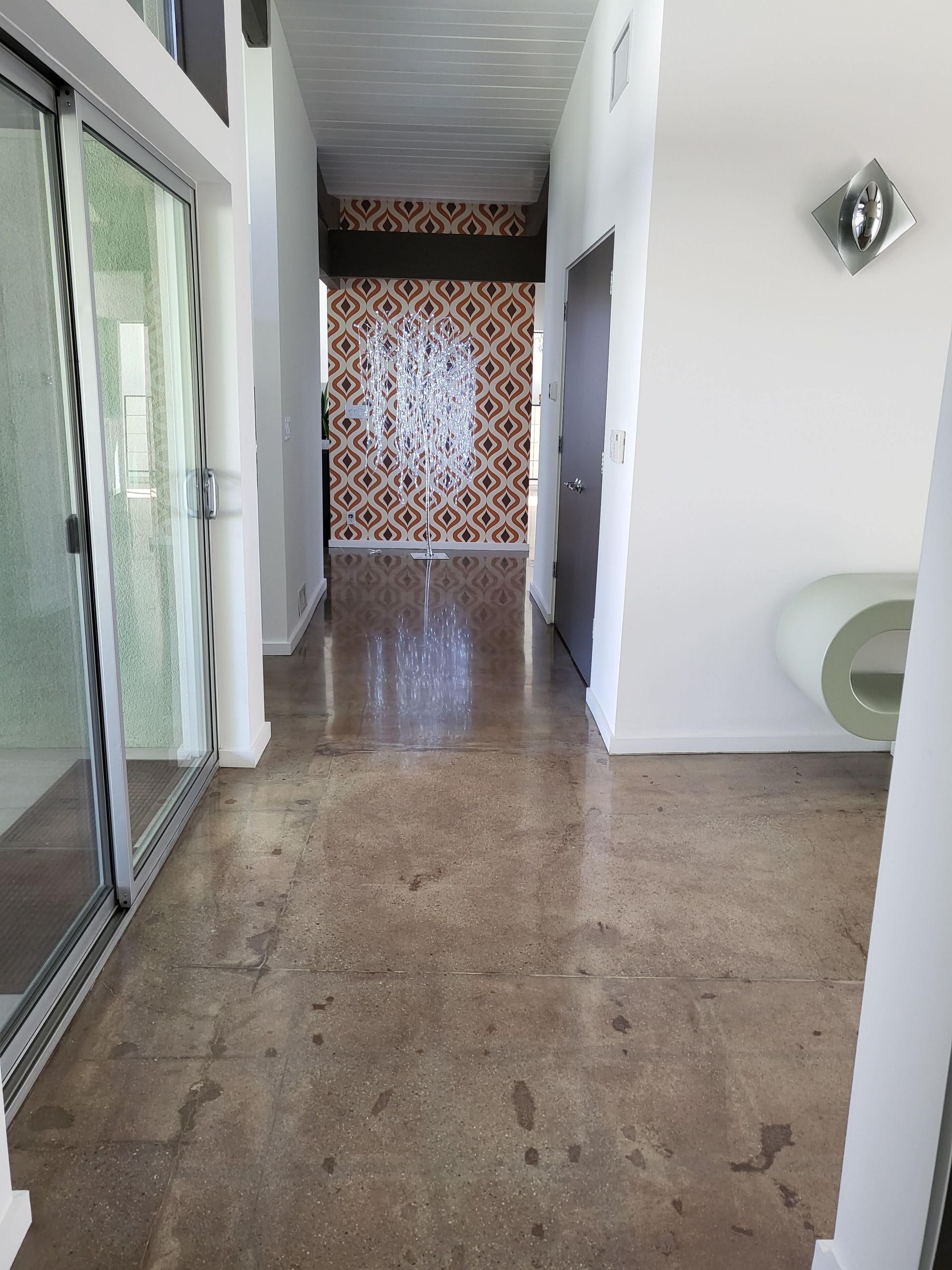A long hallway with sliding glass doors and a clock on the wall.