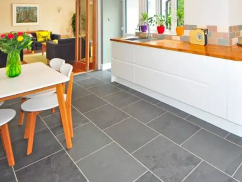 a kitchen with a table and chairs and cleaned black tile and grout in Palm Springs CA.