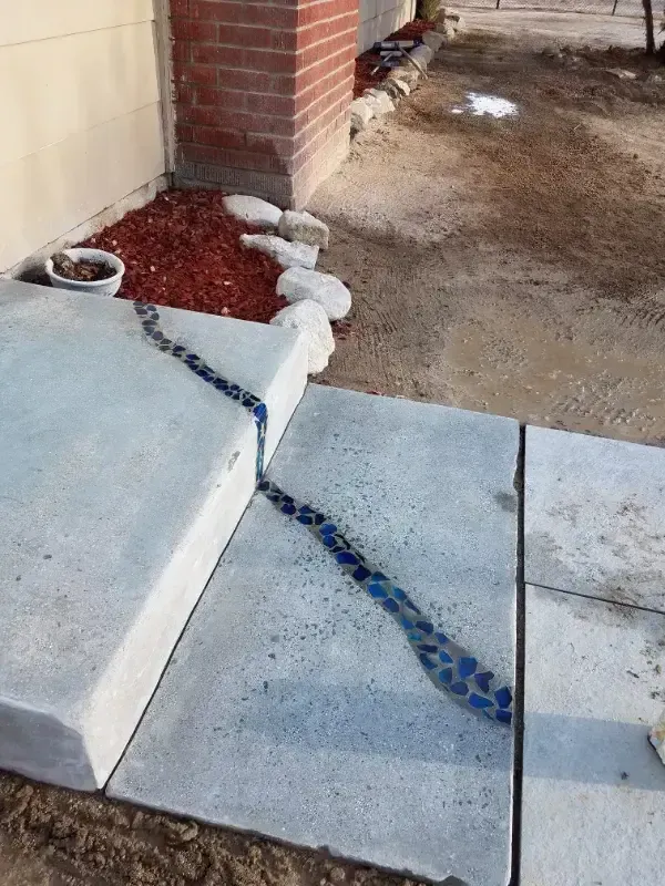 A concrete walkway is being built in front of a brick building.