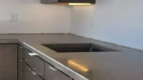 Modern kitchen countertop with built-in stovetop and dark cabinets