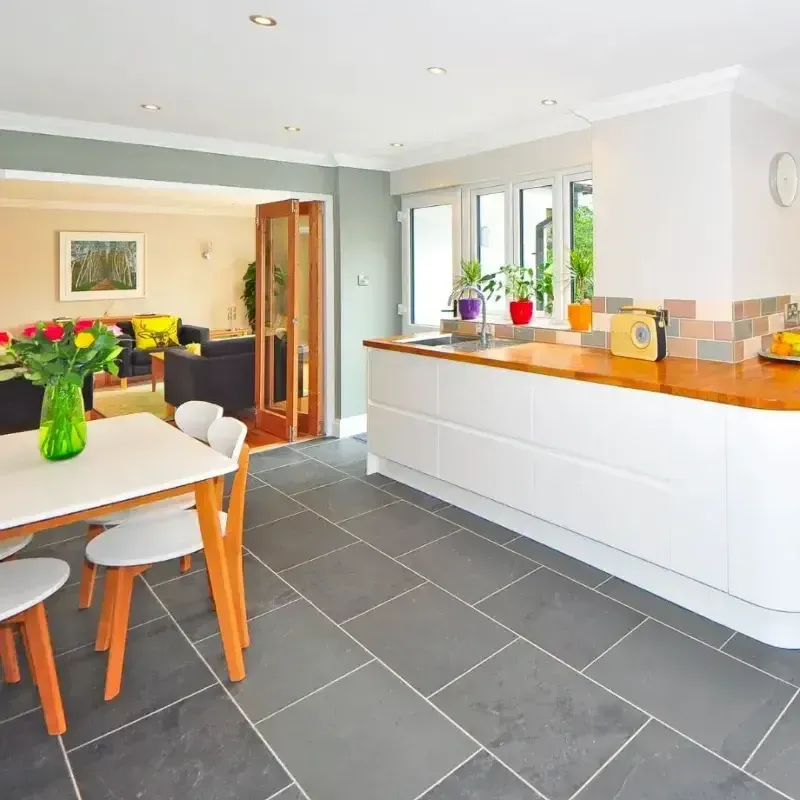 A kitchen with a table and chairs and a vase of flowers