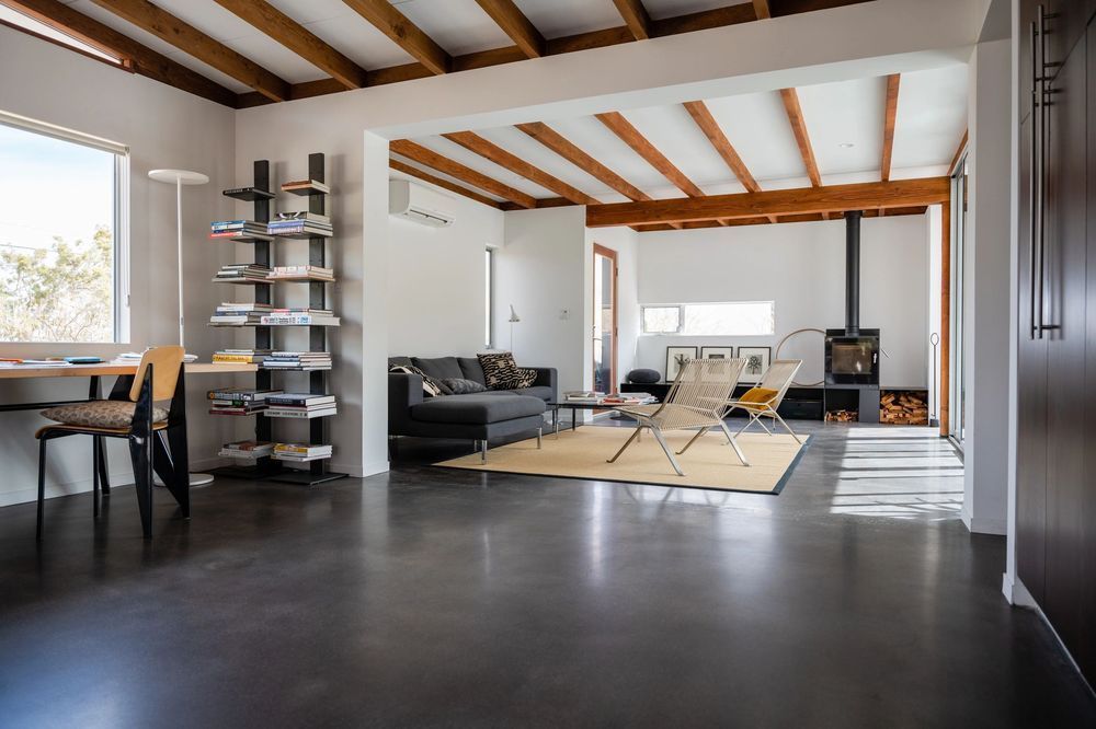 A living room with a couch , chairs , a desk and a fireplace.