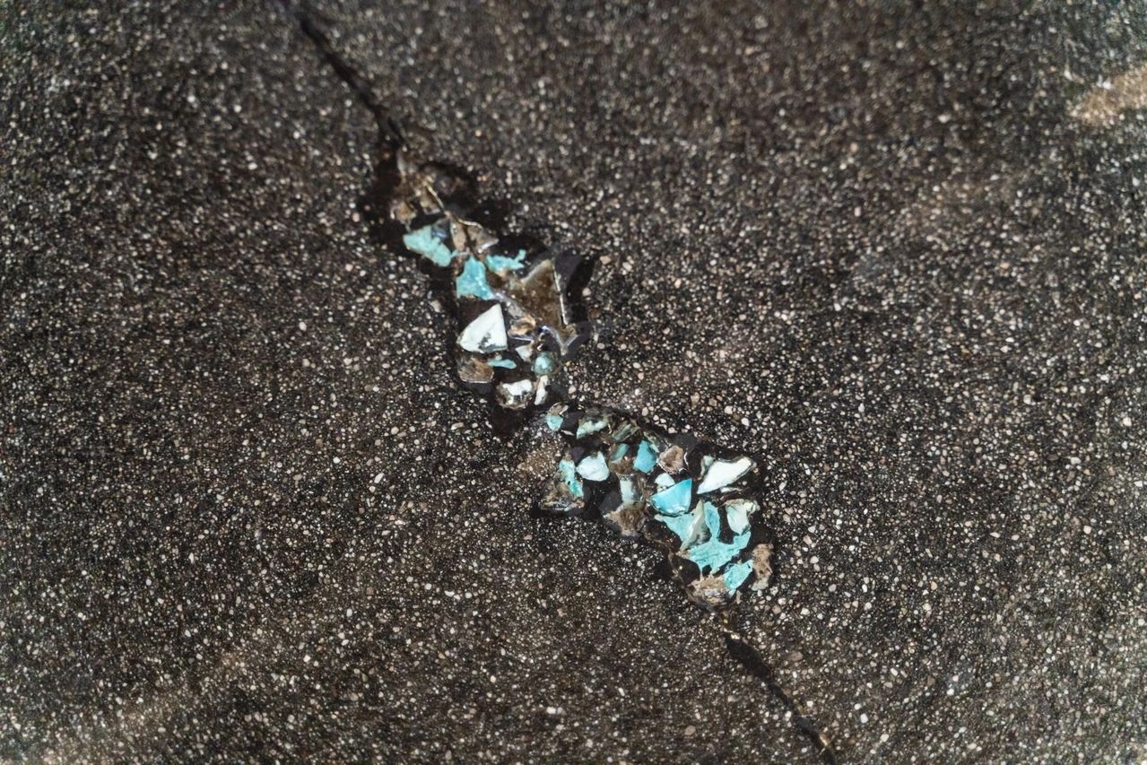 A close up of a turquoise bracelet on a black surface