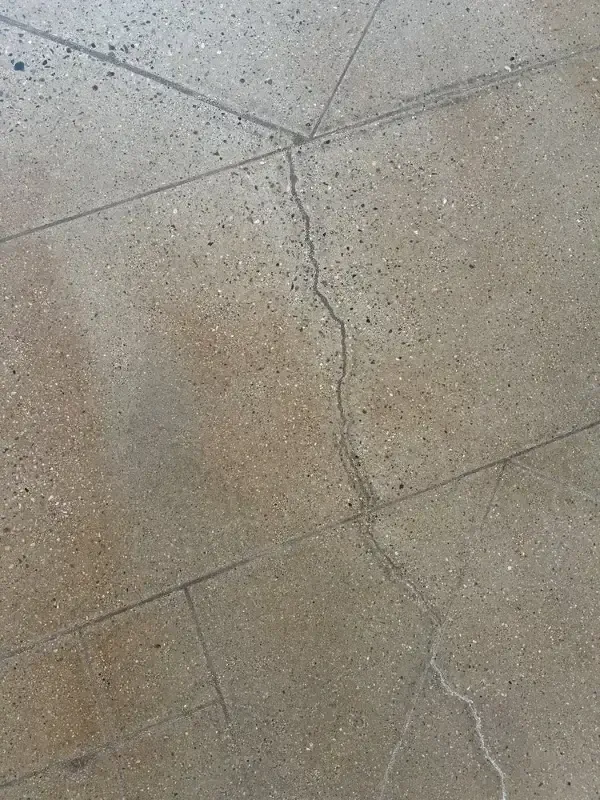 Gray tiled floor with long, thin cracks.