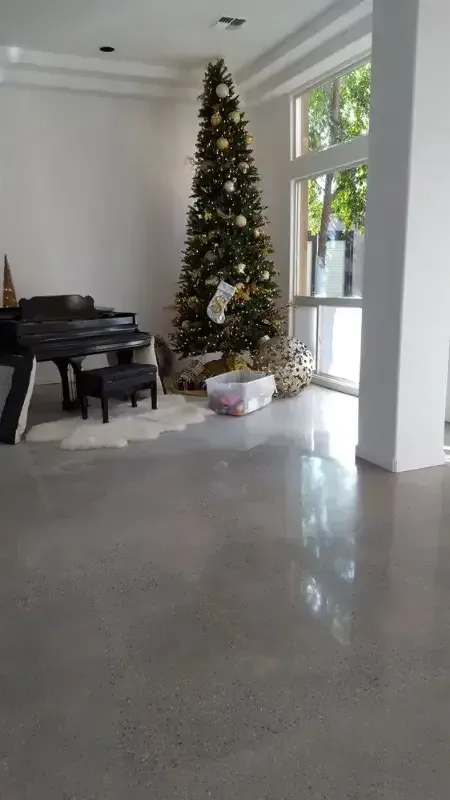 A living room with a piano and a christmas tree.