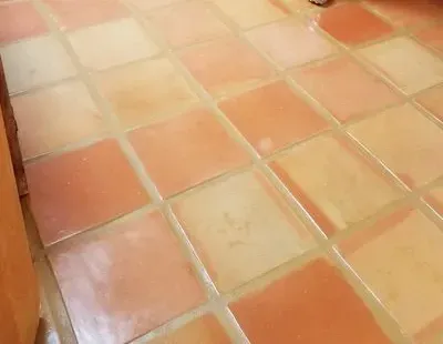 White clawfoot bathtub on orange tiled bathroom floor