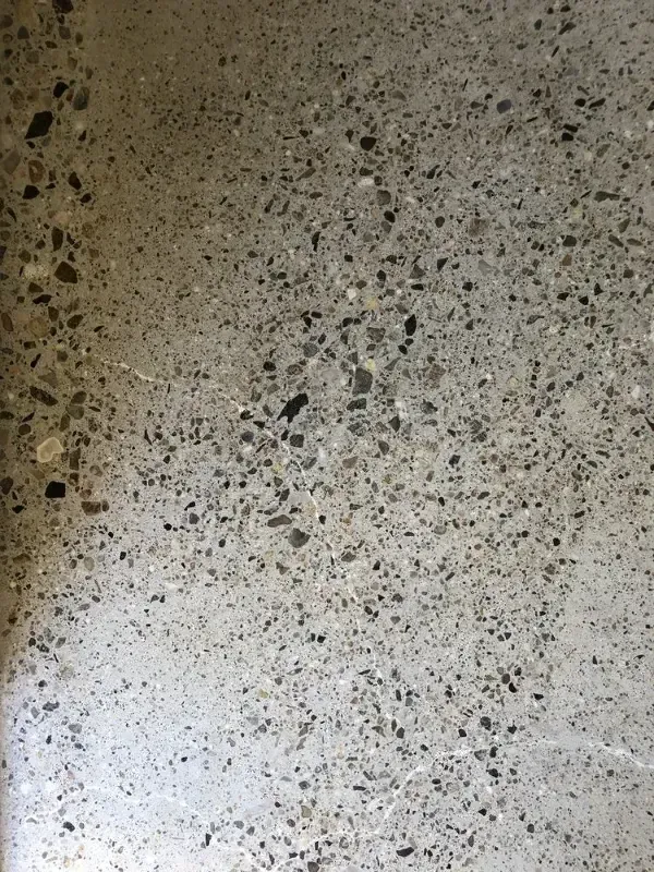 A close up of a concrete surface with a lot of small rocks on it