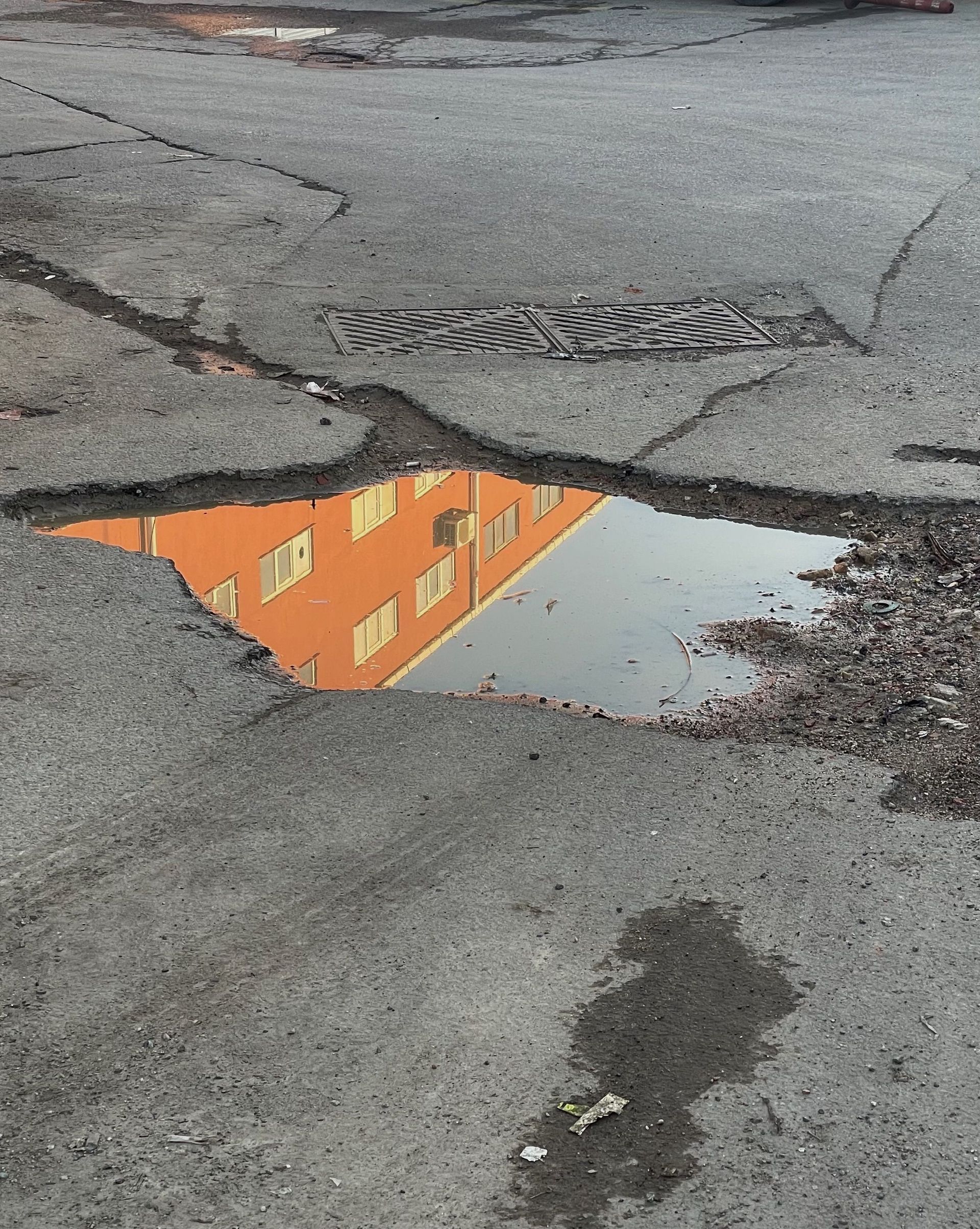 Cracked asphalt with a puddle | Total Auto Services