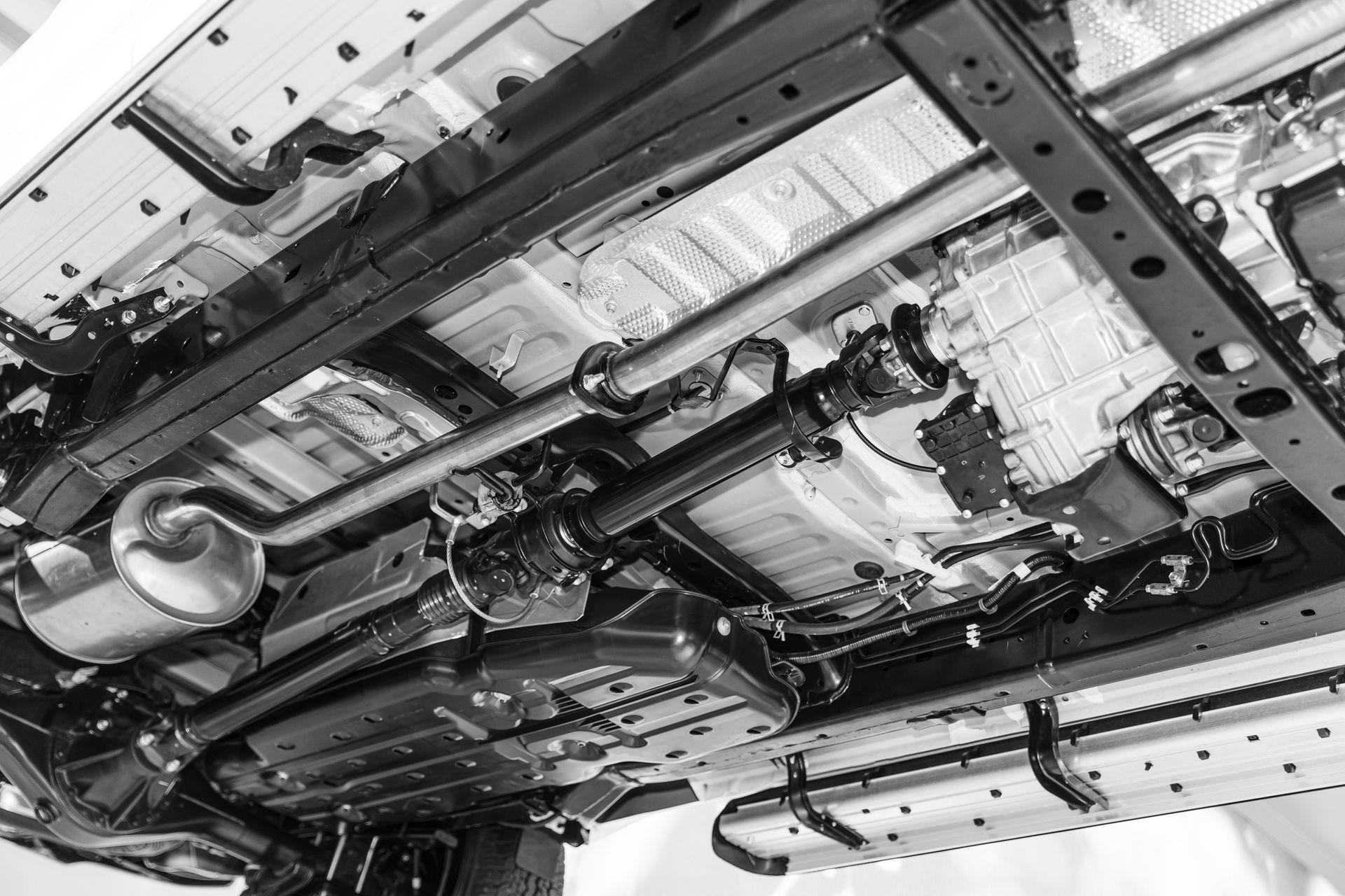 Under-car frame showing drive shaft and silencer muffler assembly.