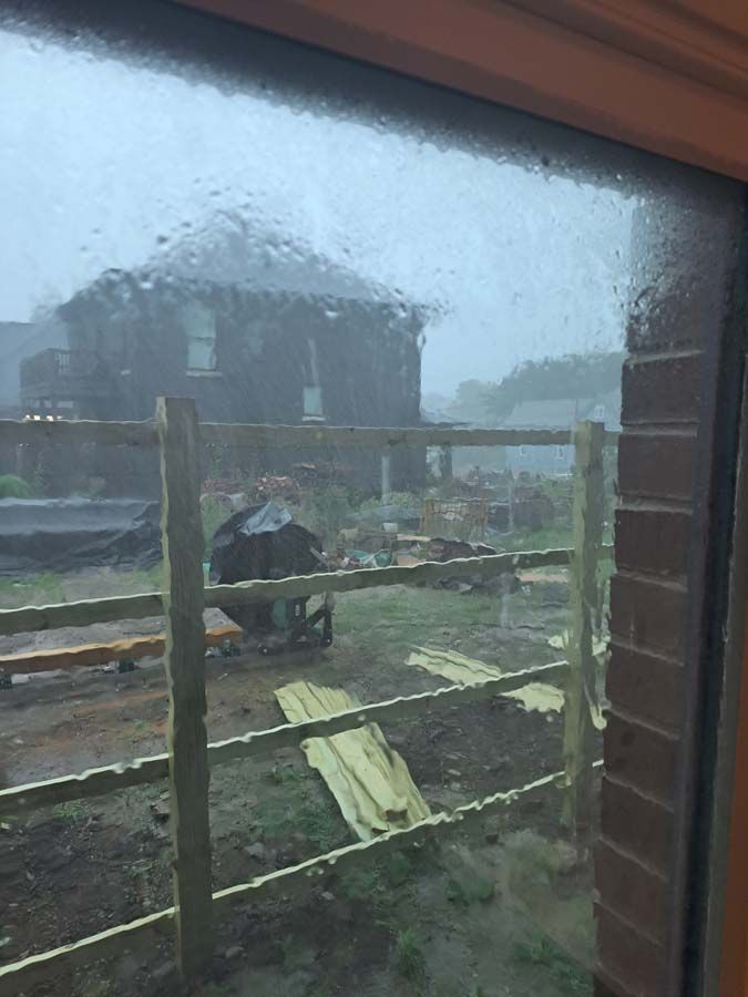 A window with a fence and a house in the background