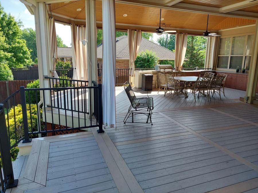 There is a large deck with a table and chairs on it.