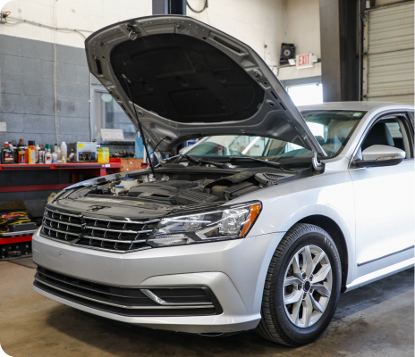 Silver sedan with hood open in an auto repair shop garage | Trask Automotive