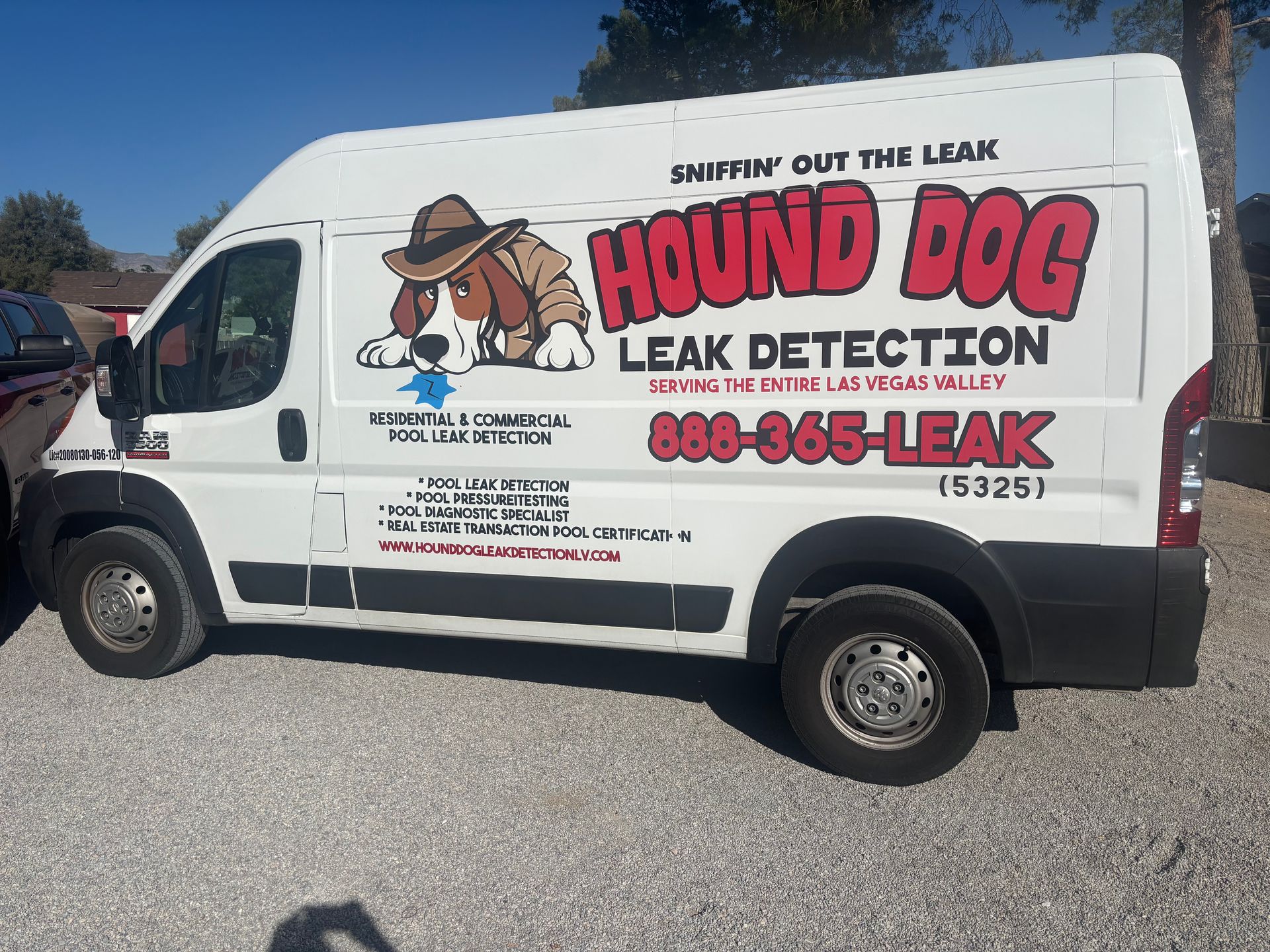 Five people in blue shirts standing in front of a white van with a cartoon logo.