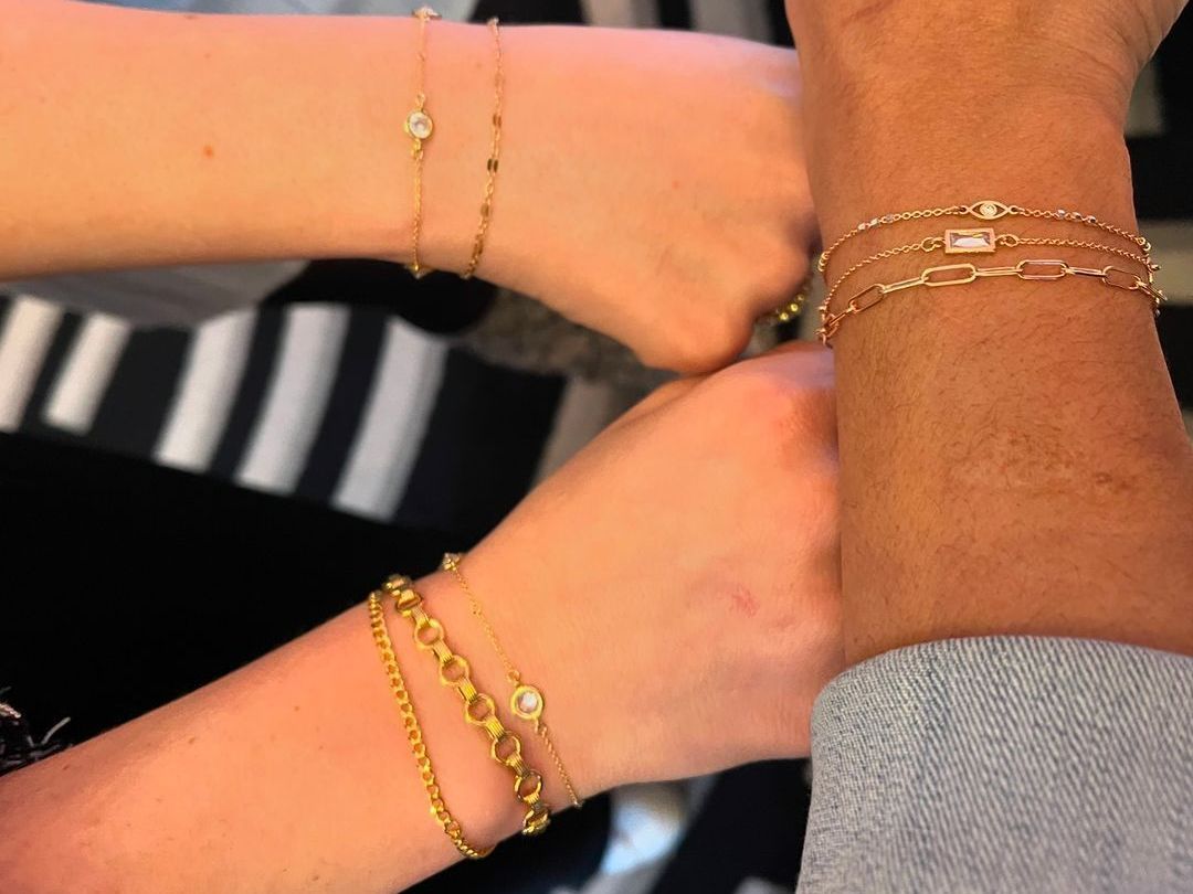 A person wearing a bandana and a gold chain around their wrist
