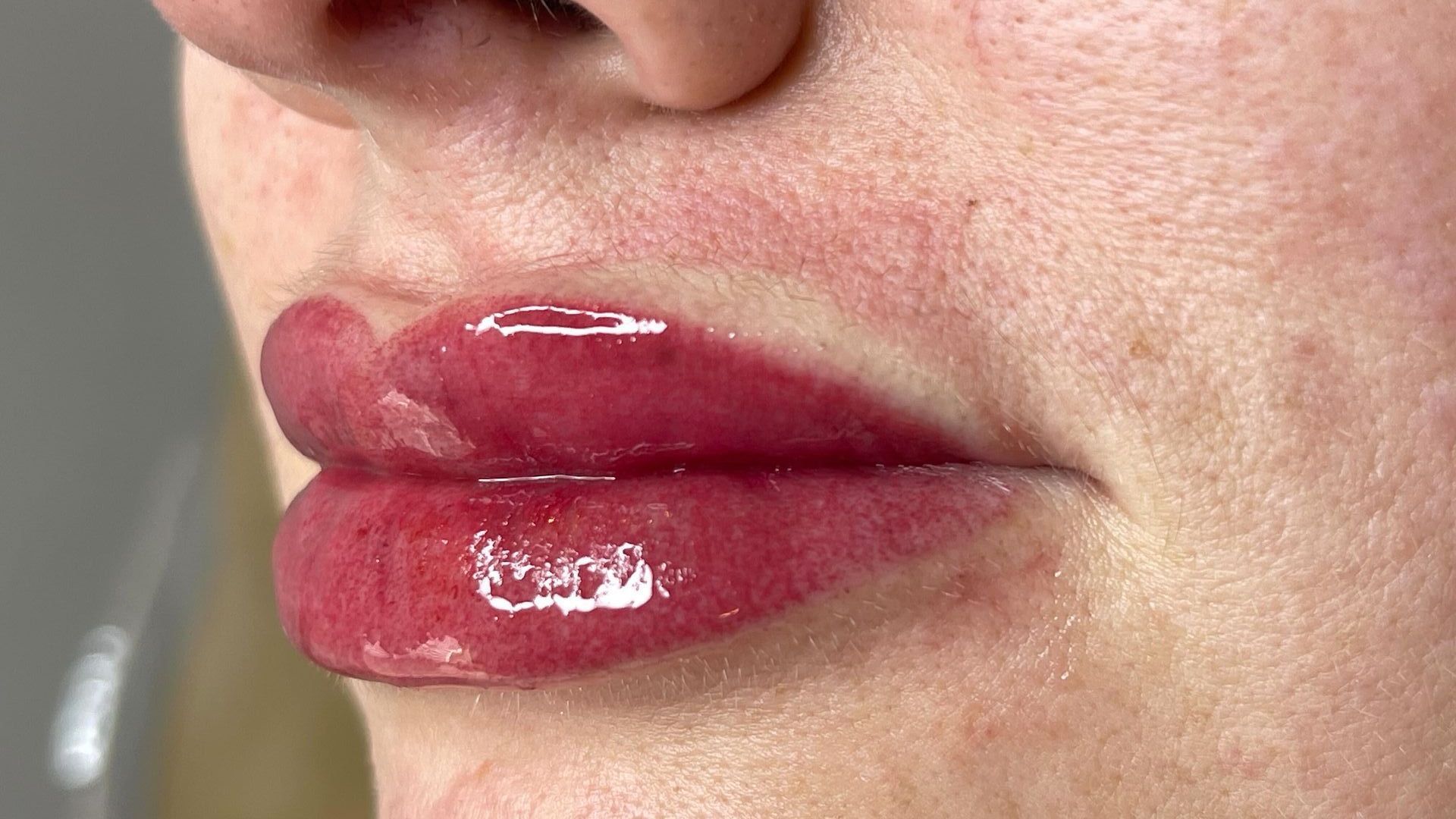 A close up of a woman 's lips with red lipstick.