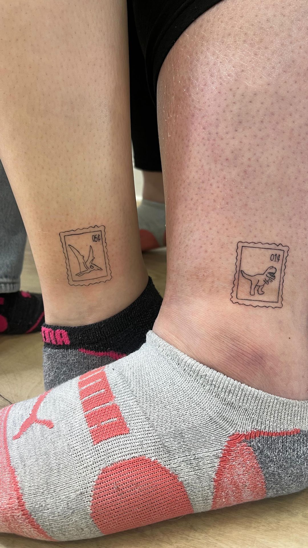 A person with two small tattoos on their ankles.