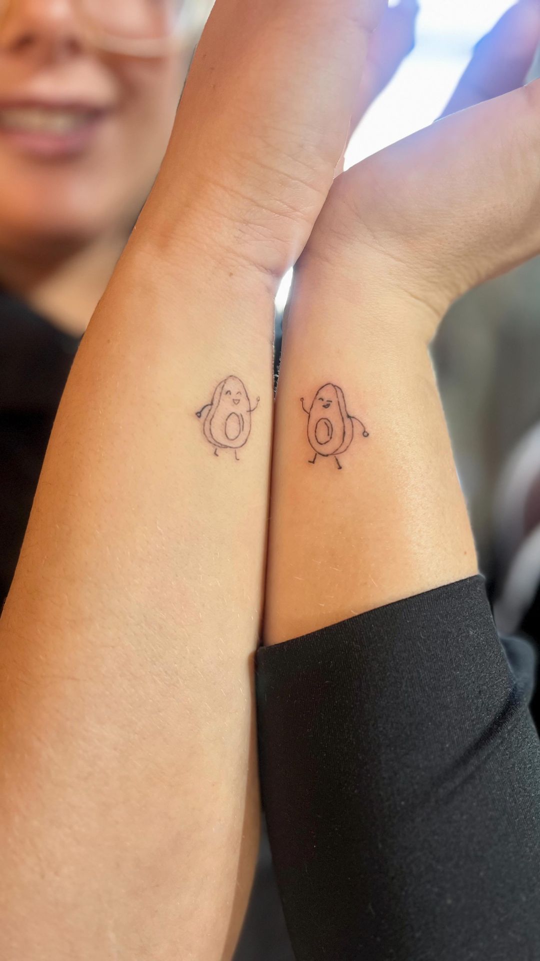 A woman has two small tattoos on her wrists.