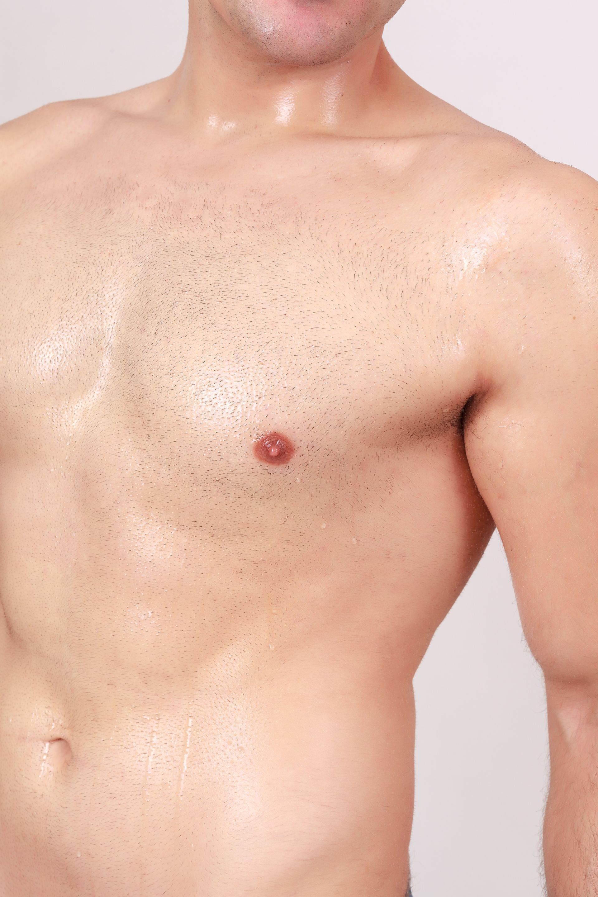 A close up of a man 's chest with a red spot on it.