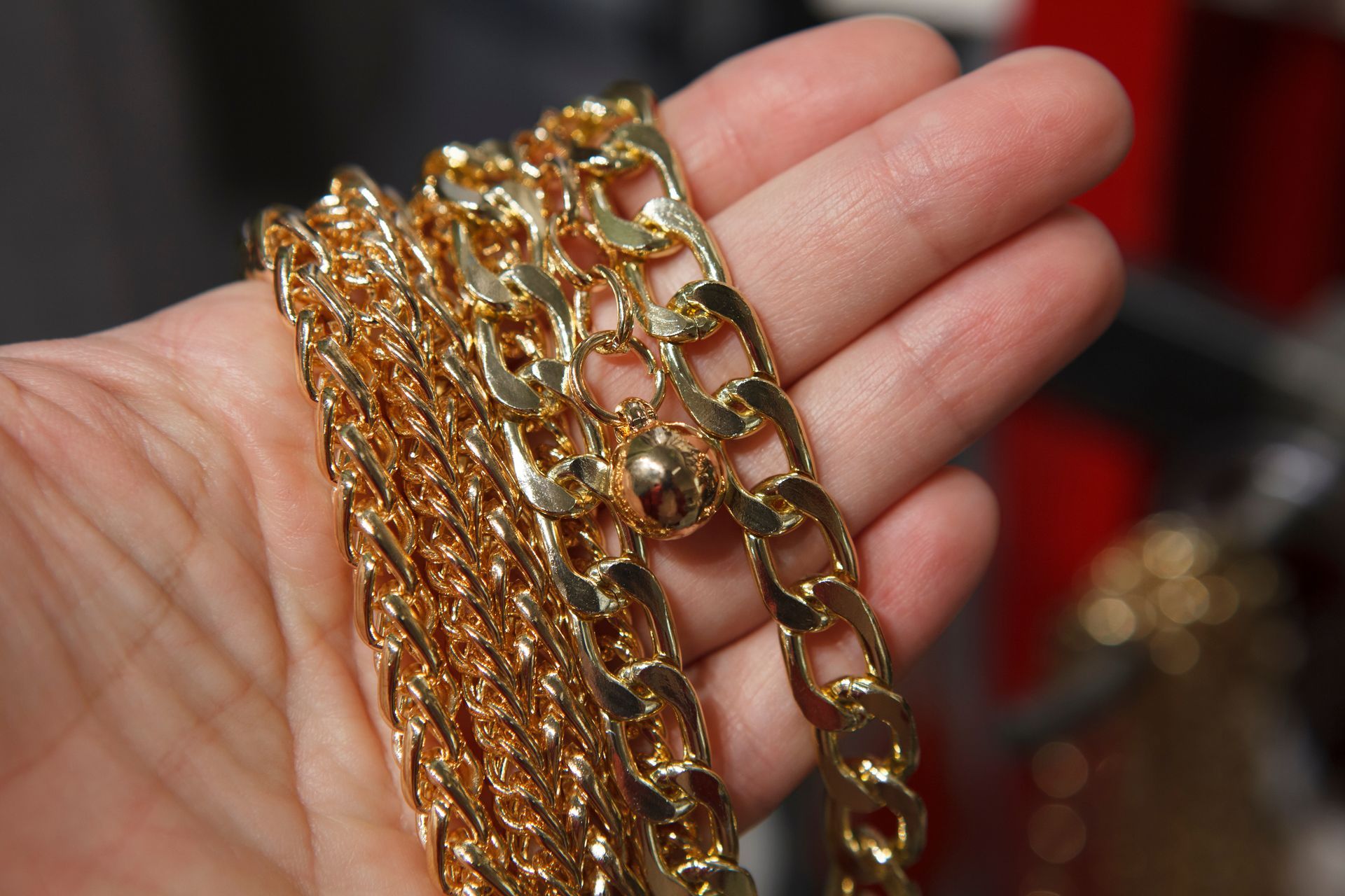 A person is holding a gold chain in their hand