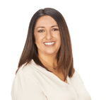 A woman in a white shirt is smiling for the camera.