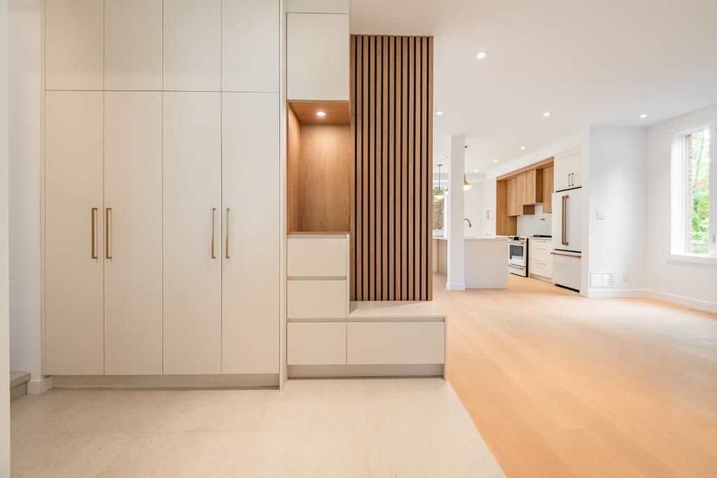 Des meubles blancs modernes et des lambris dans un intérieur lumineux et ouvert.