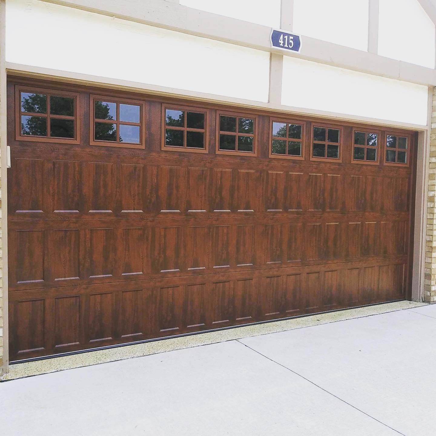 Brown garage door with windows above, house number 415.