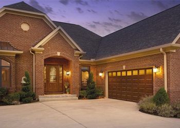 Brick house with a dark brown garage door, front door, and driveway.