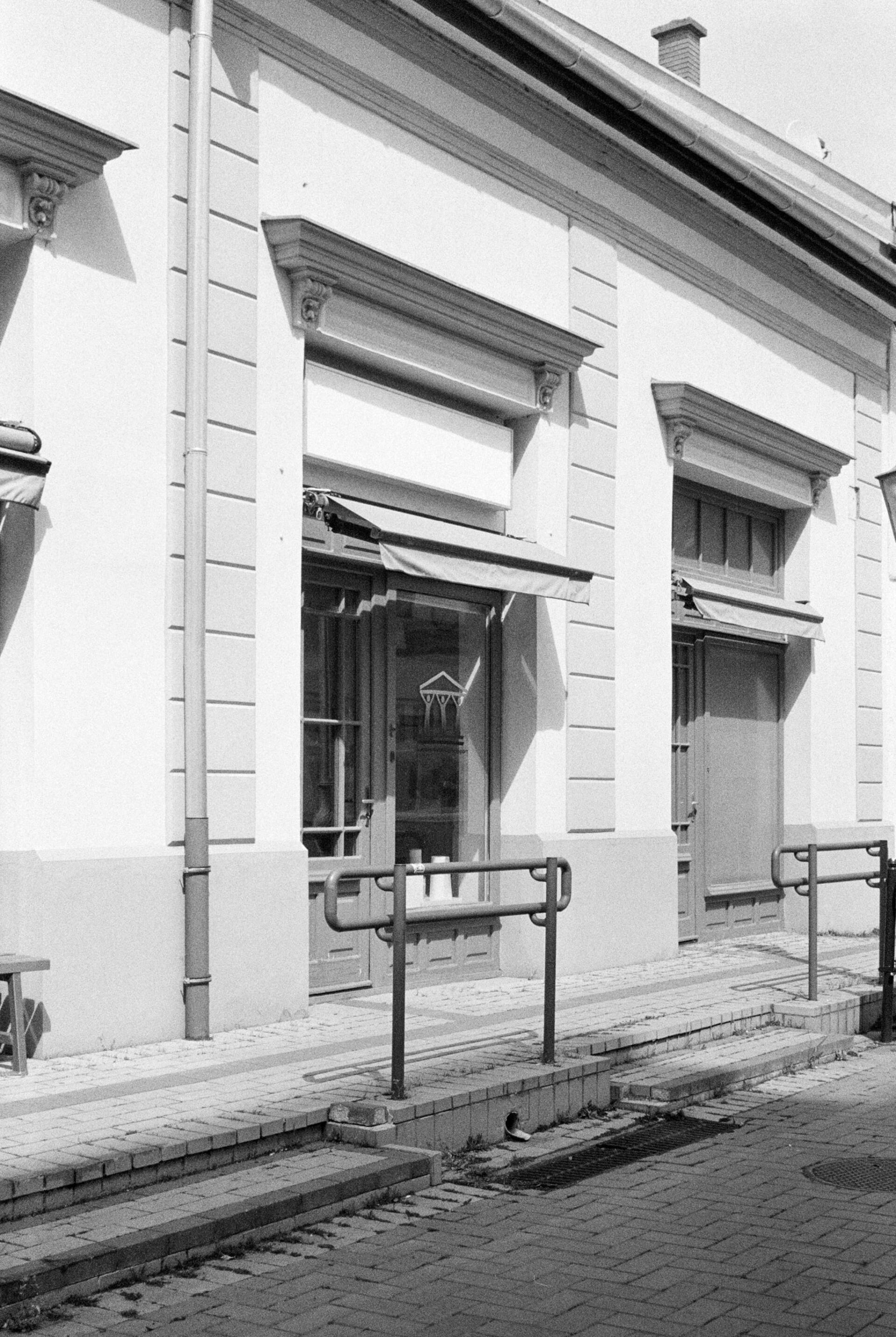 A black and white photo of a building with a railing